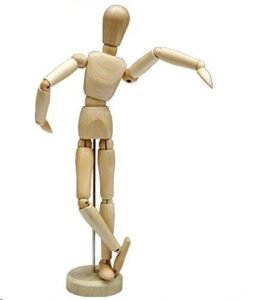 Wooden artist's mannequin in a dancing pose, standing on a wooden base